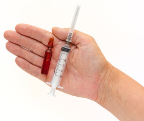 Isolated top view of woman hand holding ampoule with vitamins group B for injection and syringe on...