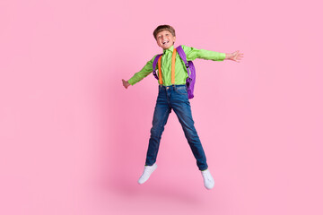 Full length body size view of handsome trendy boy nerd jumping good mood isolated over pink pastel...