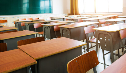 Empty classroom with desks, chairs and chalkboard