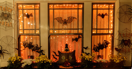 Halloween decorations hanging outside residential building window at night of trick or trick