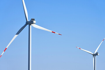 Windmill blades in close-up on a pale blue background. Copy space.
