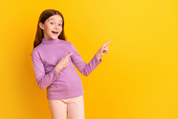 Photo of happy excited positive good mood little girl point fingers copyspace advertisement isolated on yellow color background