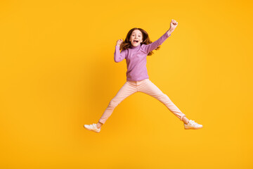 Fototapeta na wymiar Full length body size view of attractive lucky cheerful girl jumping rejoicing having fun isolated over bright yellow color background