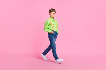 Fototapeta na wymiar Full length body size view of attractive content boy walking isolated over bright pink color background