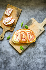 Healty bread hot  sandwich  with  rolled yellow cheese and ham    and cherry tomatoes .  Home made breakfast