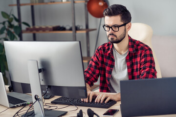 Portrait of attractive experienced focused guy writing creating code security database development at office work place station indoor