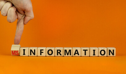 Information or misinformation symbol. Businessman turns cubes and changes the word misinformation...