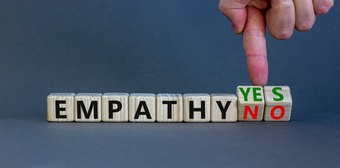 Empathy yes or no symbol. Psychologist turns wooden cubes and changes words empathy no to empathy yes on a beautiful grey background. Psychological and empathy yes or no concept, copy space.