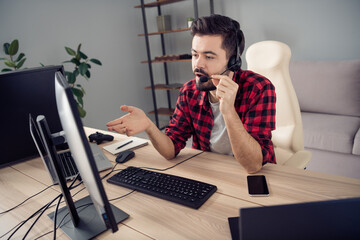 Portrait of attractive trendy guy answering incoming calls talking with client providing care at...