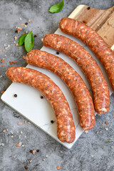 Raw pork  sausages  ready for cooking with spices  on  marble cutting board