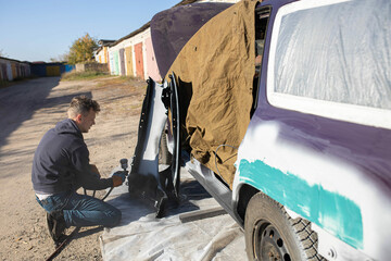 man treat car body with primer for painting, body repair