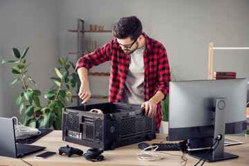 Portrait of attractive focused skilled trendy guy fixing improving motherboard processor at studio...