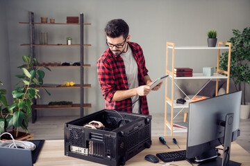 Portrait of attractive experienced trendy guy upgrading motherboard processor at studio office...