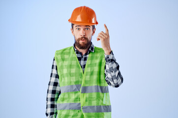 working man green vest orange helmet workflow hand gestures blue background