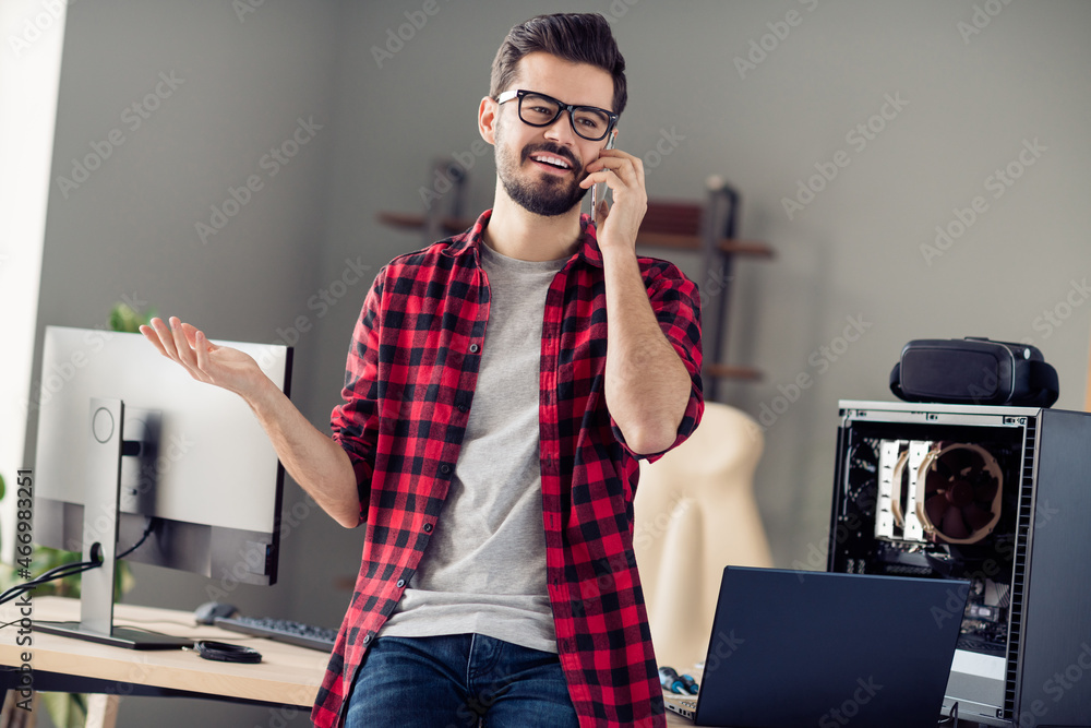 Poster portrait of attractive cheery trendy guy engineer geek calling client discussing project at office w
