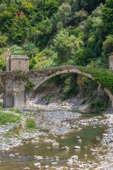 Fototapeta na wymiar Badalucco - the arch bridge ( Santa Lucia Bridge) with chapel is the symbol of the small Ligurian village, Liguria, Italy
