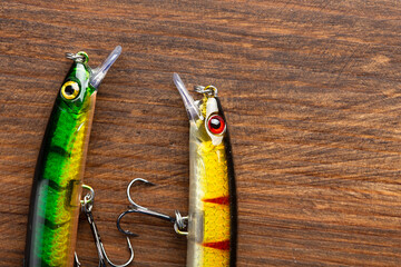 Fishing tackle - fishing spinning rod, hooks and lures on wooden background. Active hobby...