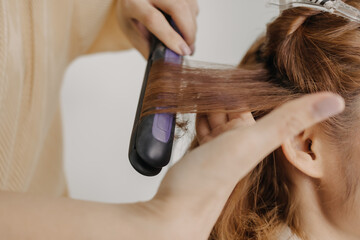 Fototapeta premium Asian woman model is dressing her hair by the hairdresser in studio room.