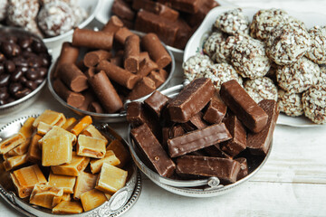 Assorted chocolate candies on wooden background. Chocolate sweets. Dessert background.