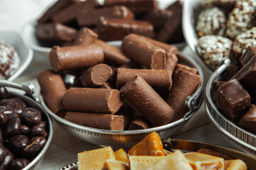 Assorted chocolate candies on wooden background. Chocolate sweets. Dessert background.