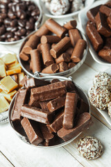 Assorted chocolate candies on wooden background. Chocolate sweets. Dessert background.