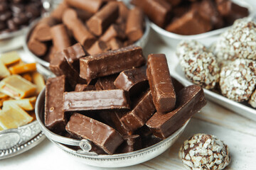 Assorted chocolate candies on wooden background. Chocolate sweets. Dessert background.