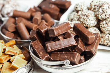 Assorted chocolate candies on wooden background. Chocolate sweets. Dessert background.