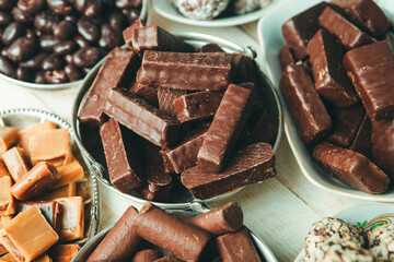 Assorted chocolate candies on wooden background. Chocolate sweets. Dessert background.