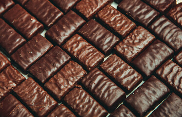 Assorted chocolate candies on wooden background. Chocolate sweets. Dessert background.