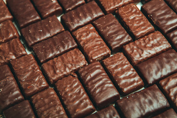Assorted chocolate candies on wooden background. Chocolate sweets. Dessert background.