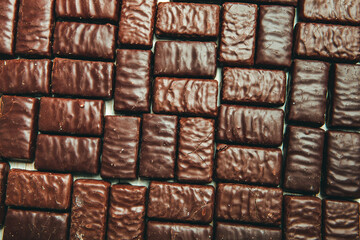Assorted chocolate candies on wooden background. Chocolate sweets. Dessert background.
