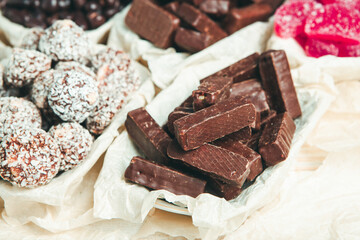 Assorted chocolate candies on wooden background. Chocolate sweets. Dessert background.