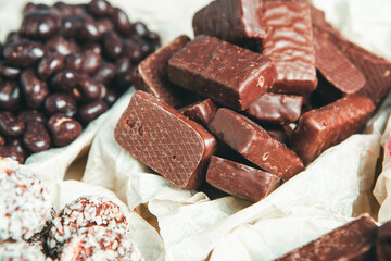 Assorted chocolate candies on wooden background. Chocolate sweets. Dessert background.
