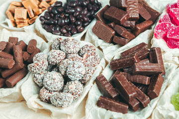 Assorted chocolate candies on wooden background. Chocolate sweets. Dessert background.