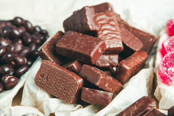 Assorted chocolate candies on wooden background. Chocolate sweets. Dessert background.