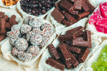 Assorted chocolate candies on wooden background. Chocolate sweets. Dessert background.