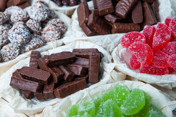 Assorted chocolate candies on wooden background. Chocolate sweets. Dessert background.