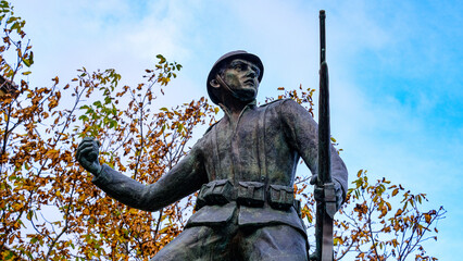 statue of soldier first world war throwing hand grenade. trees and sky on the bottom. Castelsaraceno, Basilicata, Italy.