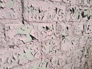 An old brick wall covered with pink paint