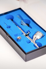 Close up of new clean airbrush tool in the blue box