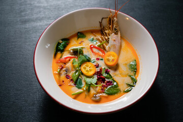 Tom yum is a spicy and sour soup with chicken or fish or shrimp or other seafood. National dish of Laos and Thailand.