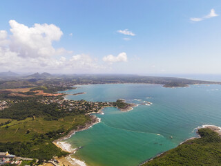 Fototapeta na wymiar Imagem de aérea da Praia em um dia ensolarado de verão. Com a Praia da Cerca e condomínio Aldeia da Praia ao fundo. Litoral Sul do Estado do Espírito Santo.