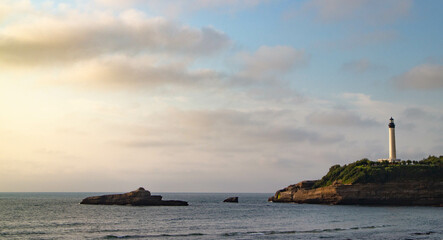 Fototapeta na wymiar coucher de soleil sur une île et son phare