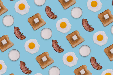 Pattern made with fried eggs, slices of crispy bacon, toast bread and glasses of milk on pastel...