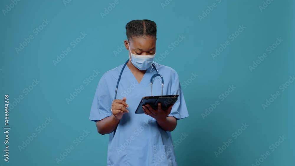 Poster medical assistant using digital tablet with touch screen in studio. woman nurse working with modern 