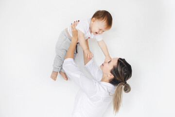 Young mother holding her little cute son above her head.