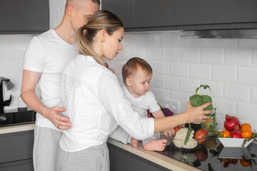 young family in the kitchen chewing vegetables