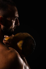 Fototapeta premium Portrait of handsome guy focusing on the dumbbell