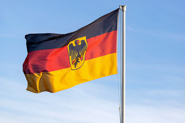 German flag with coat of arms, the so called Bundesdienstflagge, flying in the wind