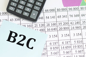 Business and finance concept. On the table there is a calculator and a business card on which the text is written B2C. BUSINESS TO CONSUMER